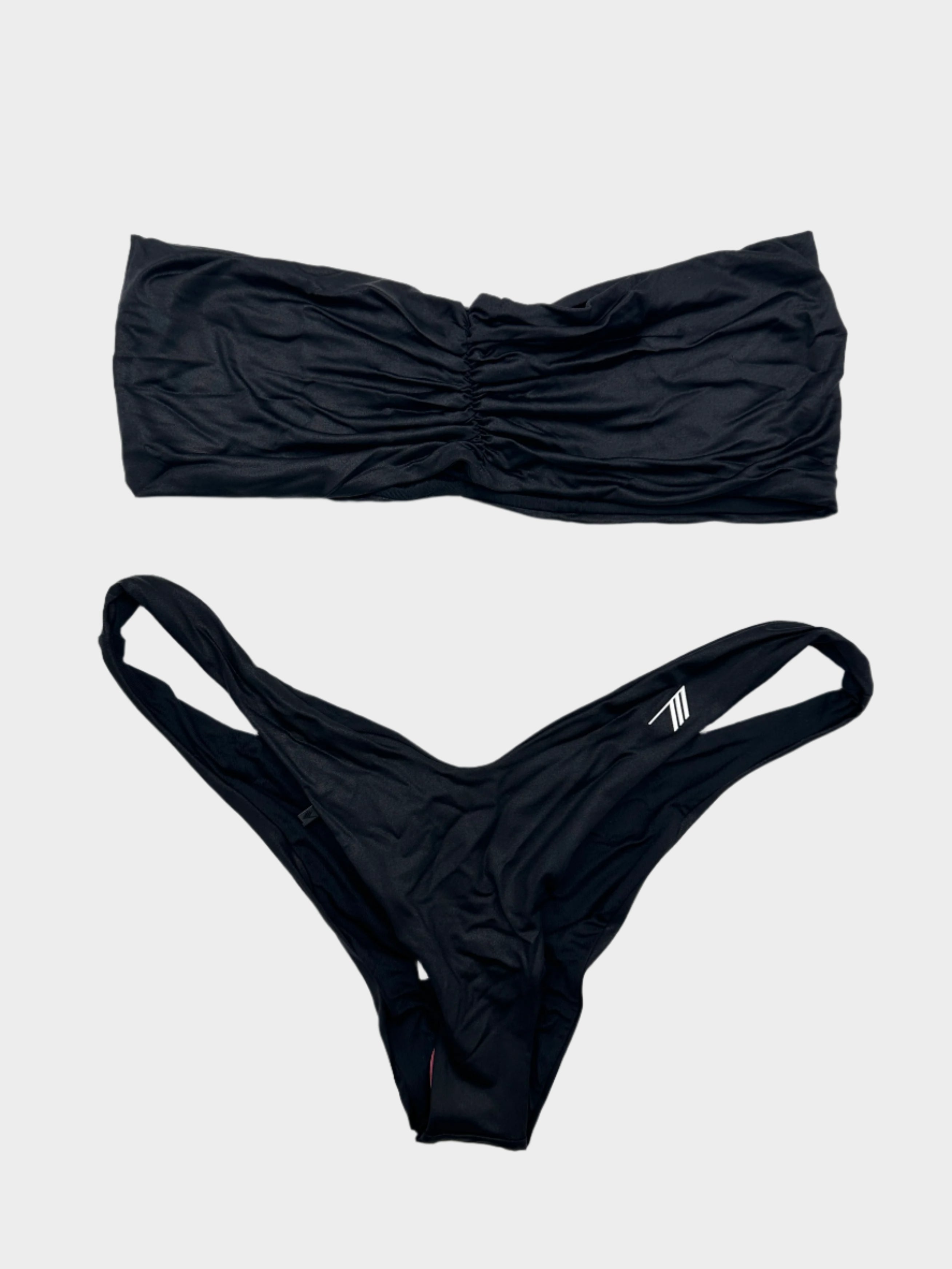 Scopri il bikini bandeau nero di The Attico. Design essenziale e dettagli esclusivi per un look elegante e audace.