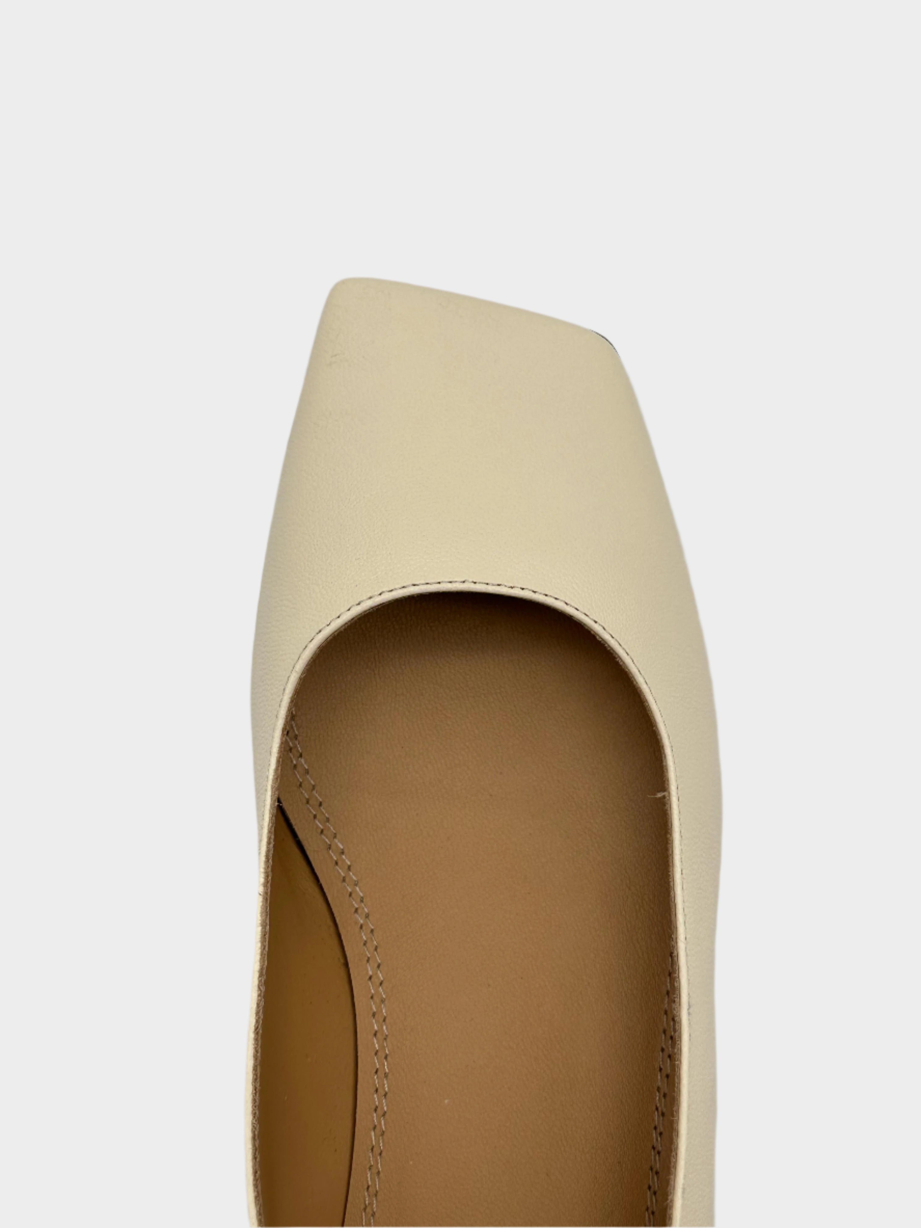 Cream-colored shoe with iconic heel detail
