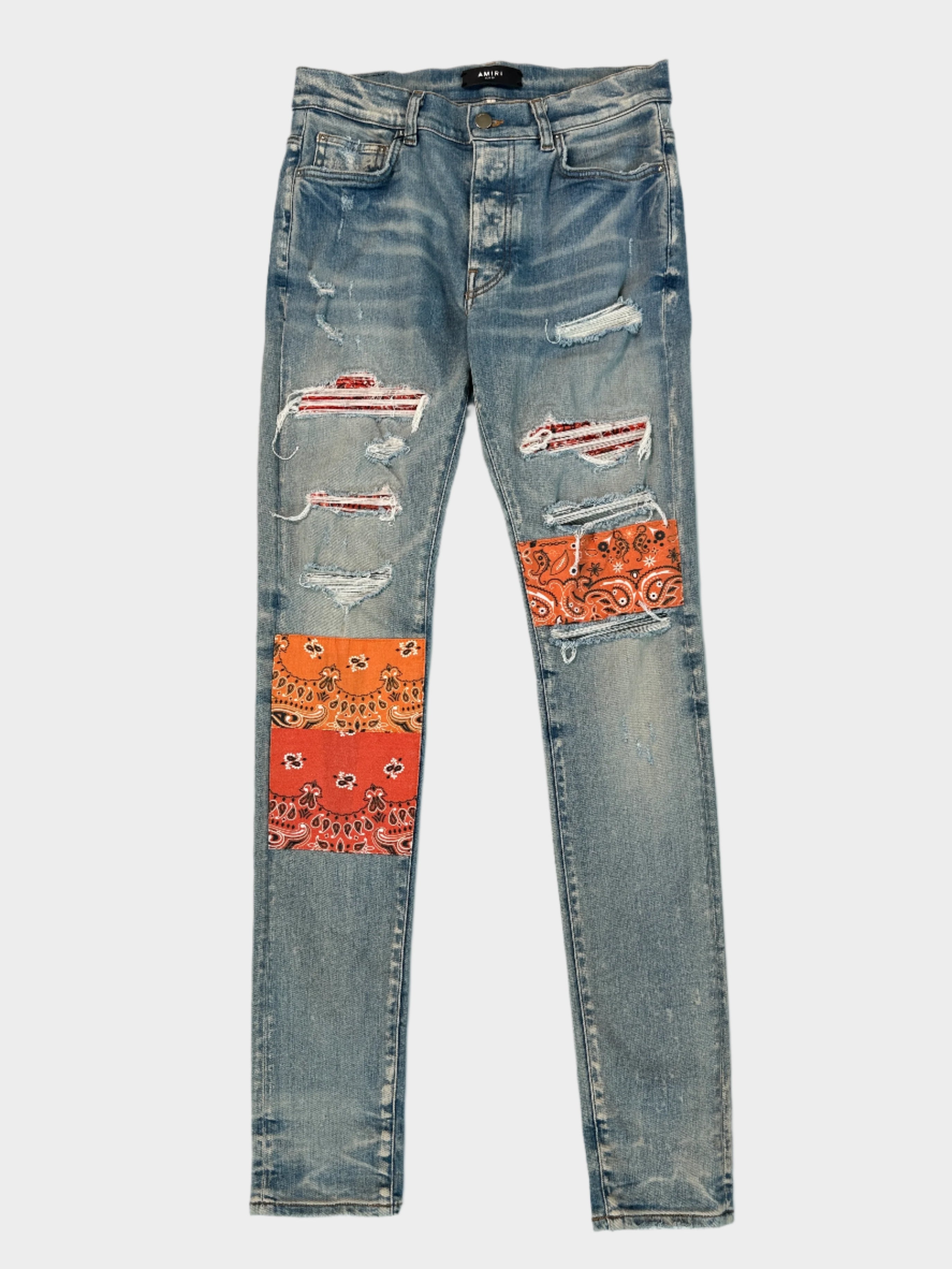 Jeans Amiri slim fit in denim strappato con patch bandana arancioni e rosse. Design audace e dettagli artigianali per uno stile unico.