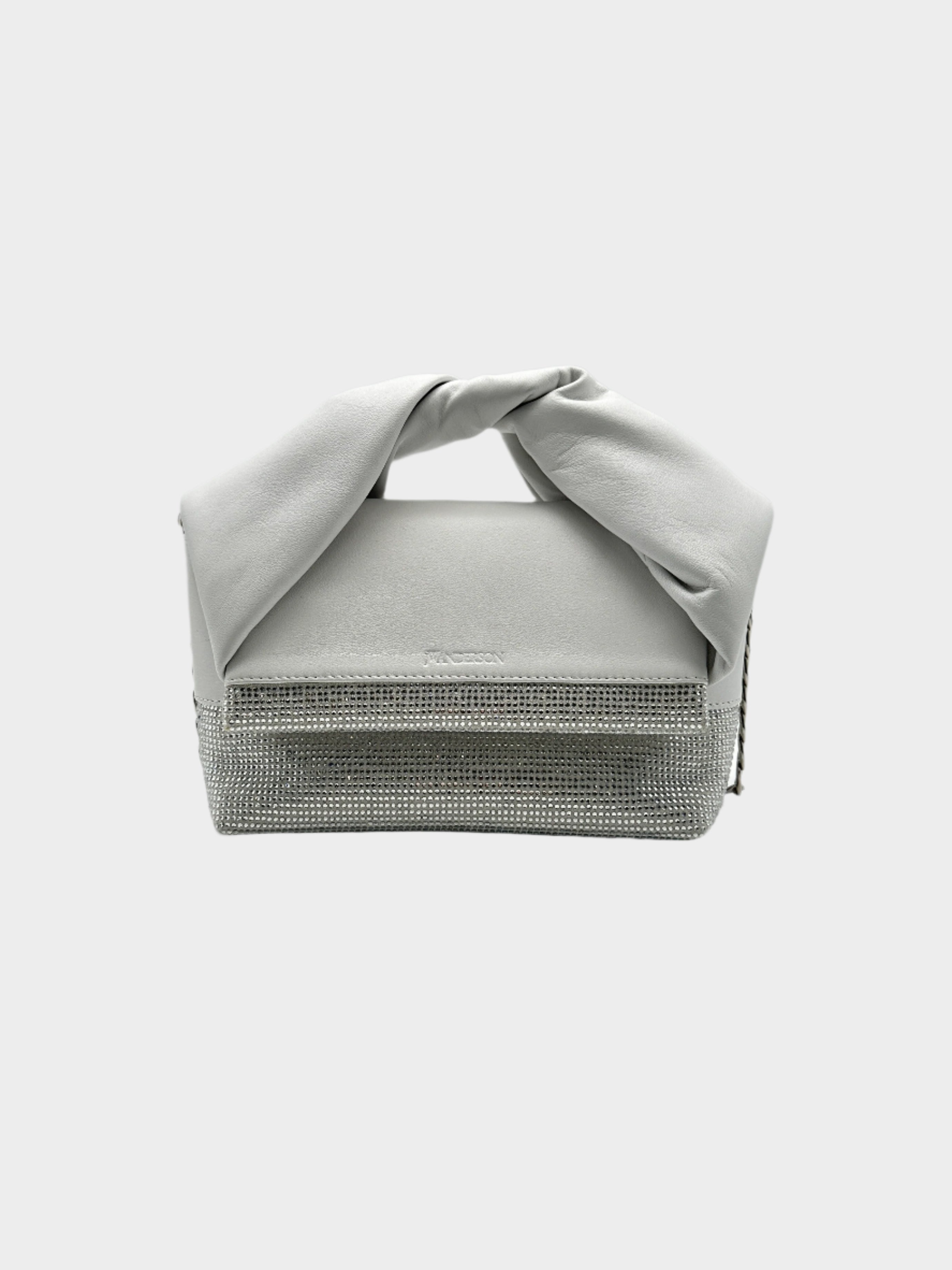 Borsa JW Anderson Twister Midi in suede grigio con cristalli. Manico annodato e design sofisticato per un look elegante e moderno.