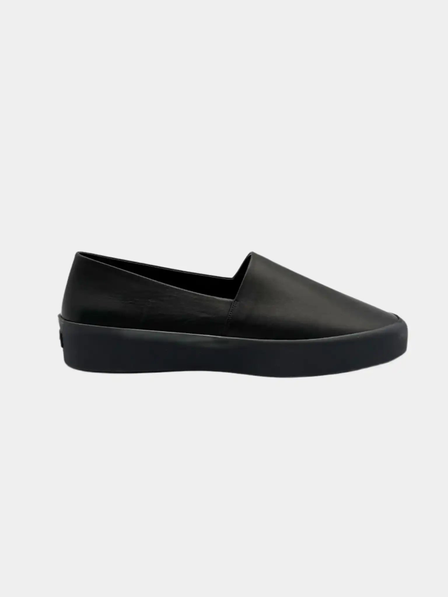 Vista laterale delle slip-on Fear of God nere in pelle