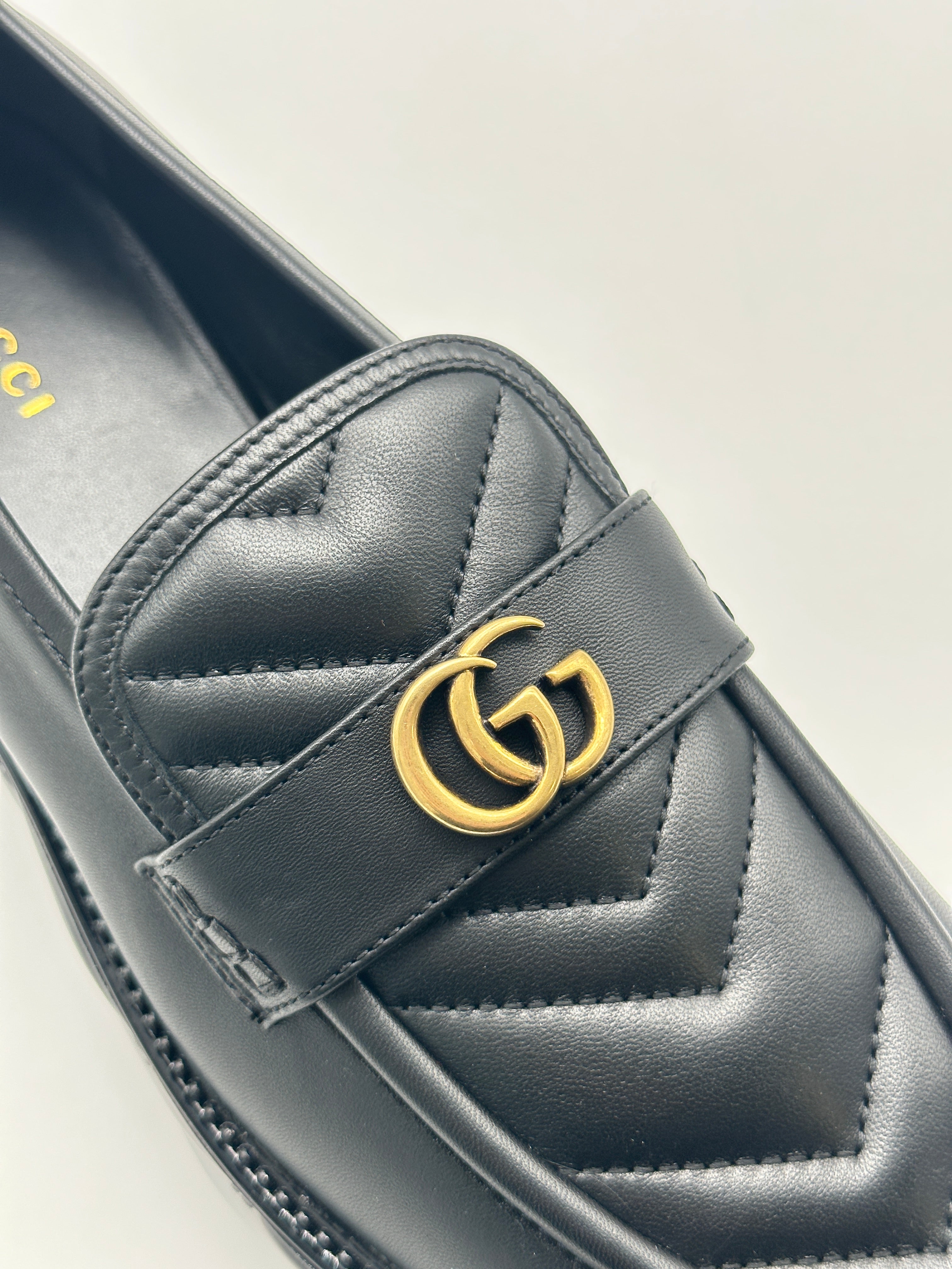 Platform Loafers con punta arrotondata, logo dorato, suola matellassé e piattaforma da 5 cm. Eleganza e comfort.