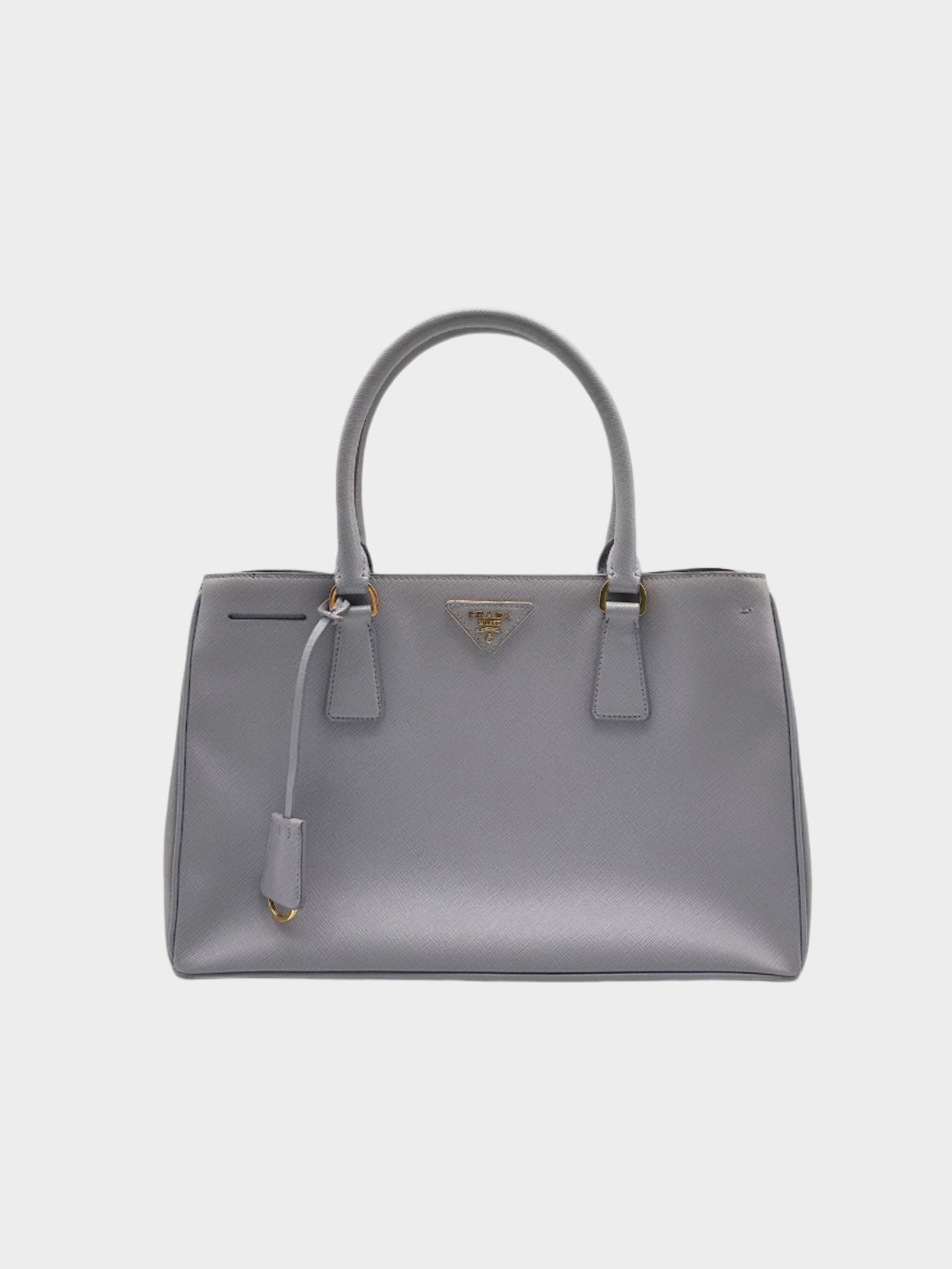 Vista frontale della borsa Prada in pelle saffiano lavanda con manici rigidi