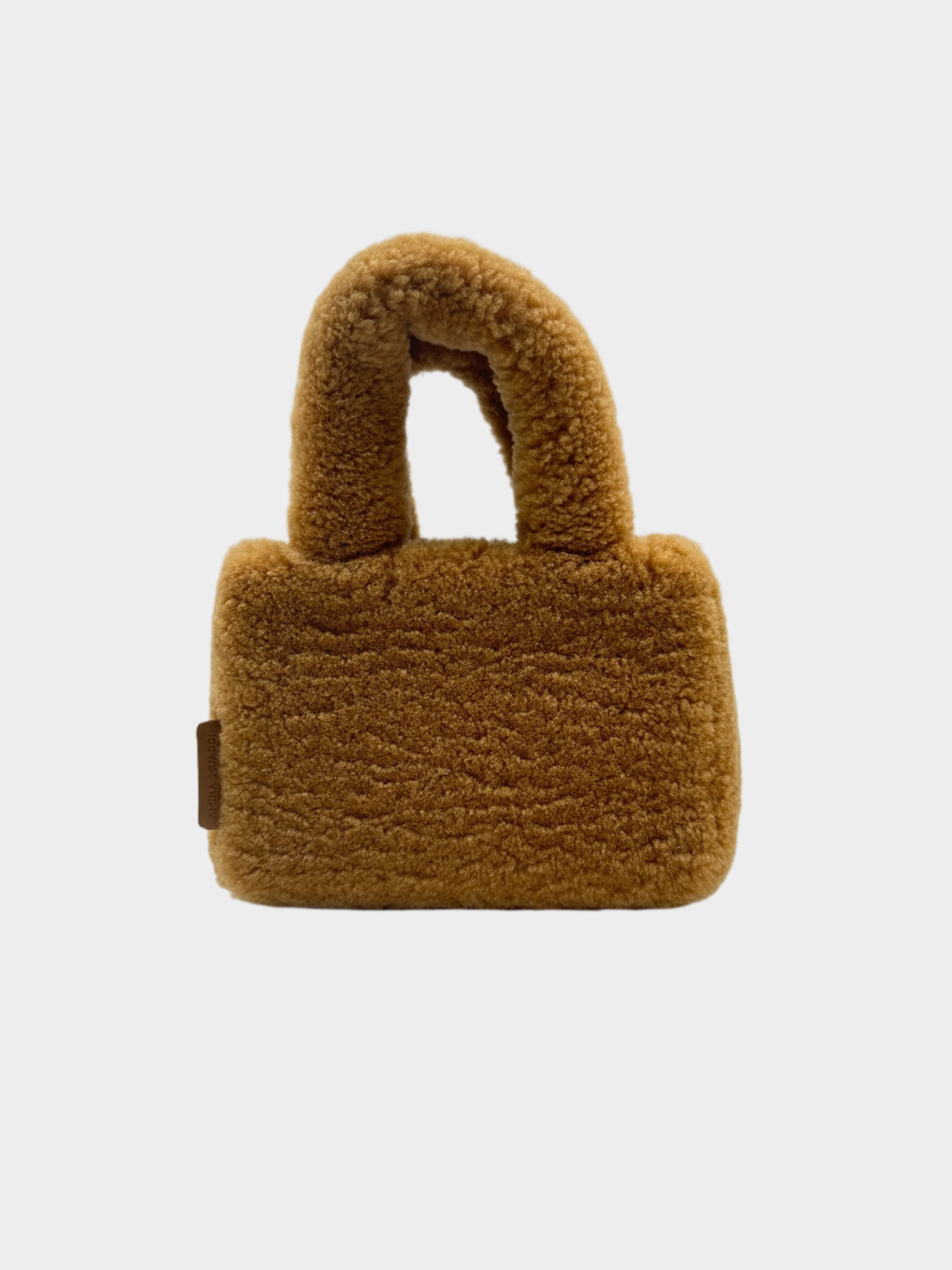 Scopri la Amini Giuly Shearling Tote Bag di Amina Muaddi, in shearling color caramello con tracolla removibile. Design compatto, nuovo con scatola originale. Acquista ora su Qlhype