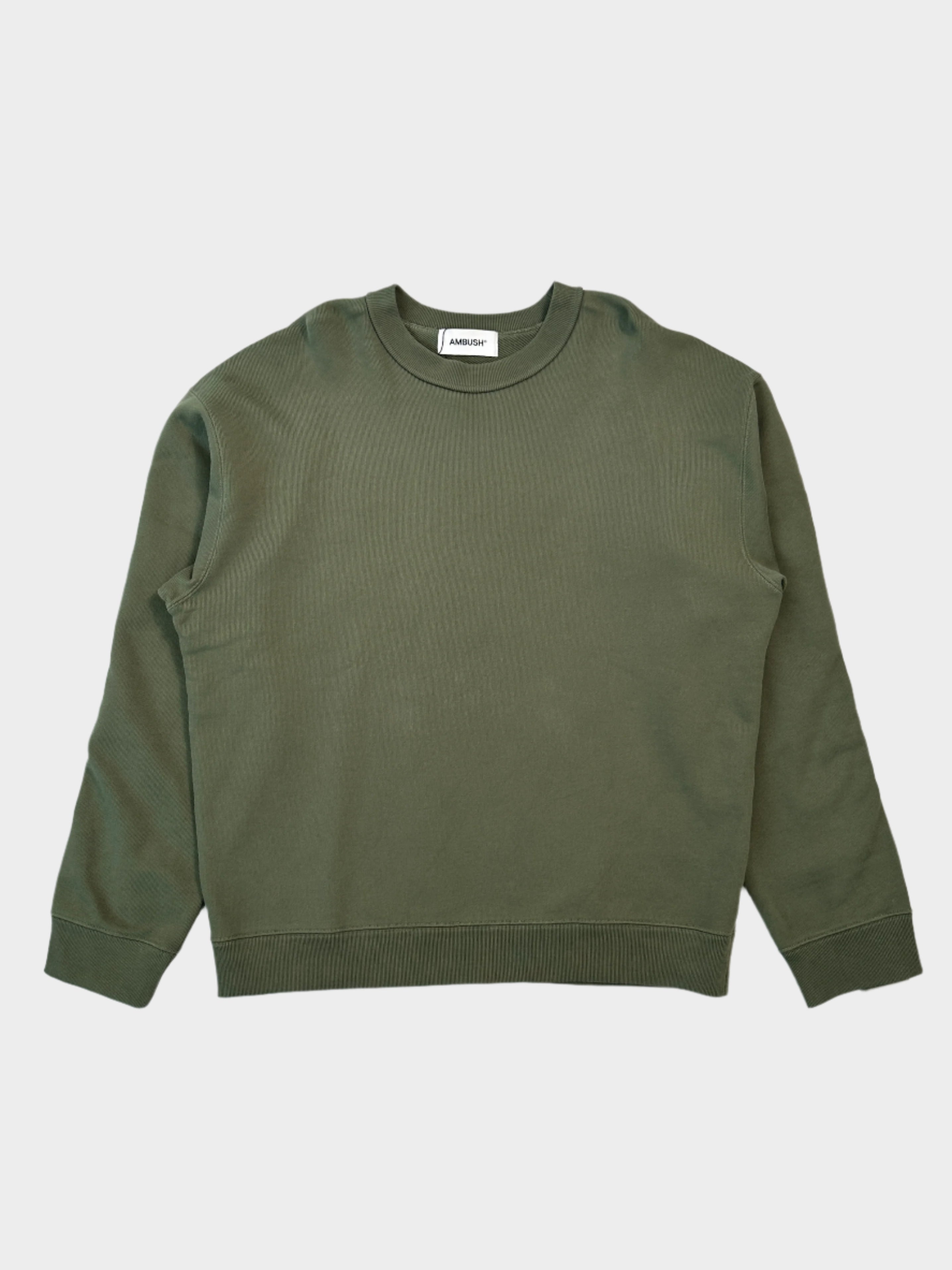 Felpa Ambush verde oliva in cotone con design minimalista. Vestibilità comoda, girocollo e polsini a coste. Perfetta per un look casual e contemporaneo.