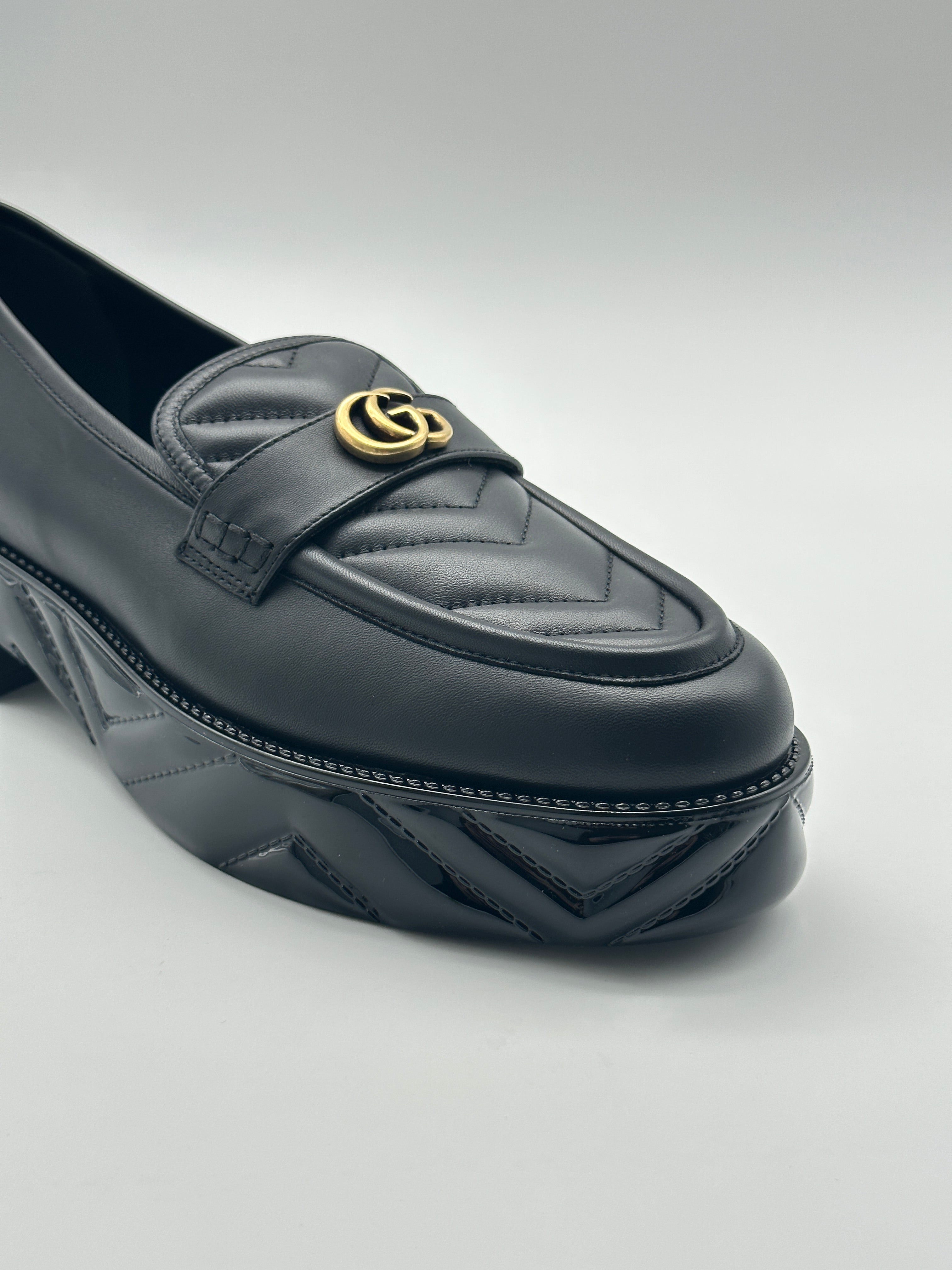 Platform Loafers con punta arrotondata, logo dorato, suola matellassé e piattaforma da 5 cm. Eleganza e comfort.