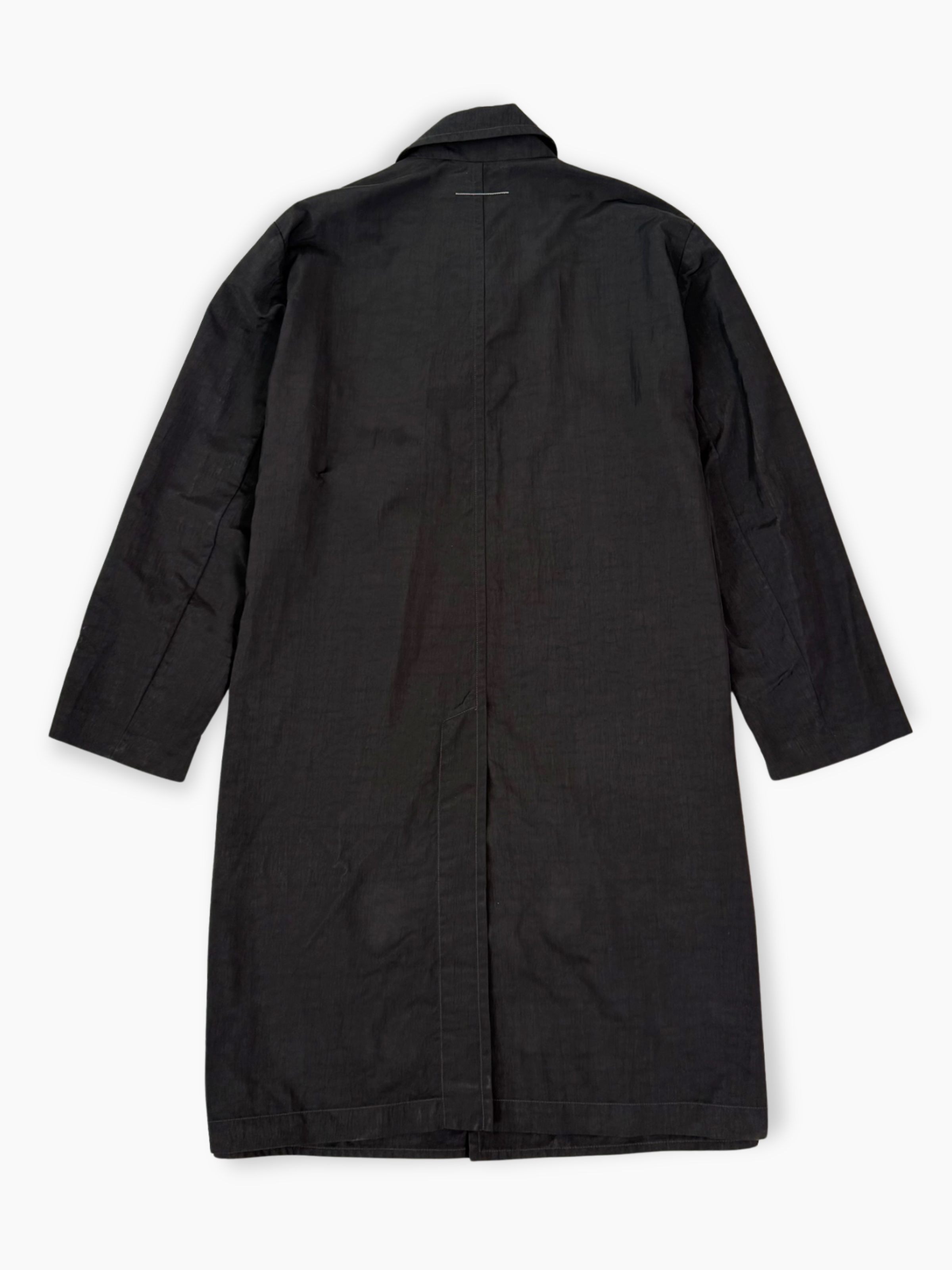 Cappotto nero Maison Margiela lungo in tessuto tecnico con chiusura nascosta