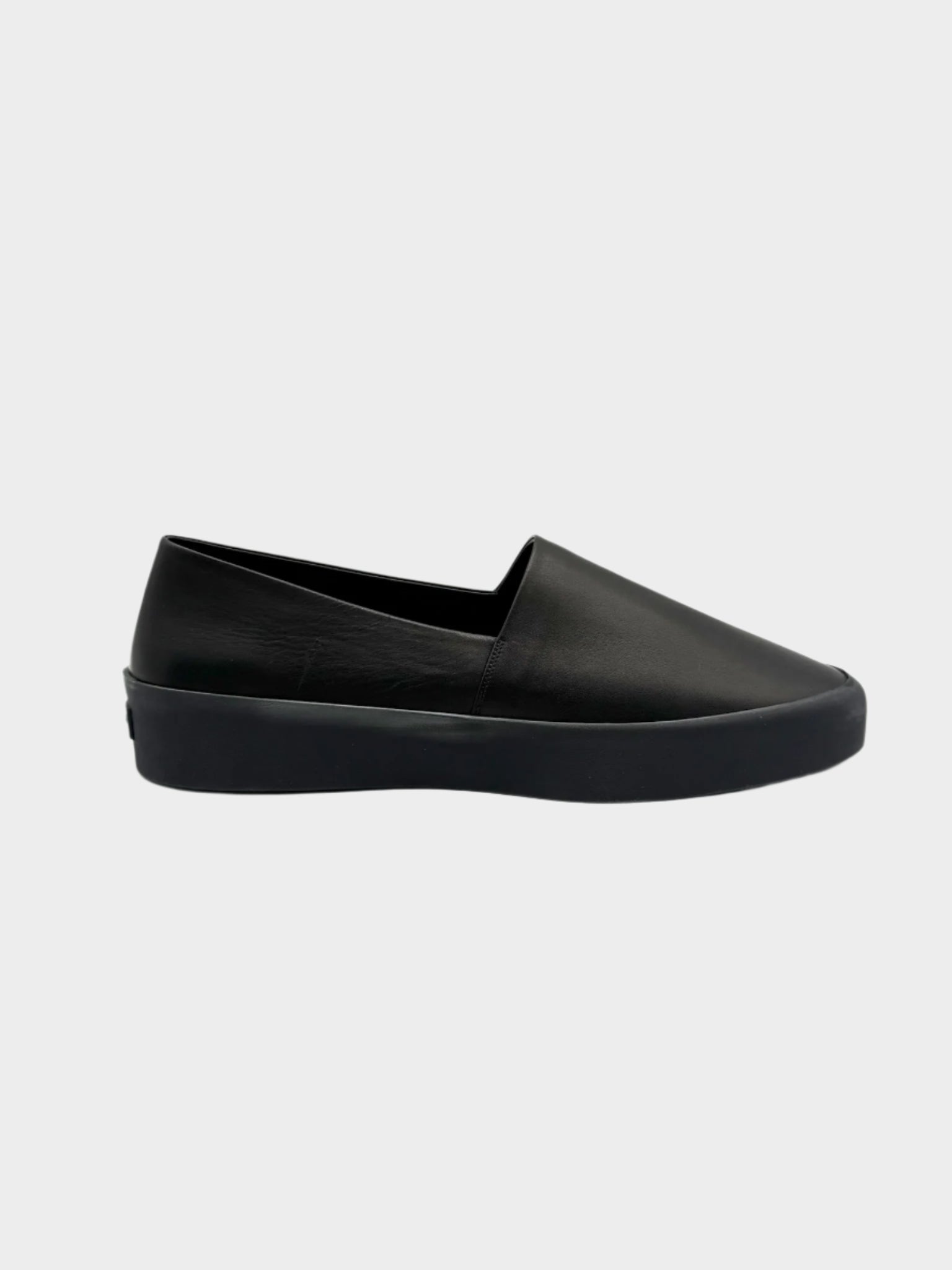 Vista laterale delle slip-on Fear of God nere in pelle