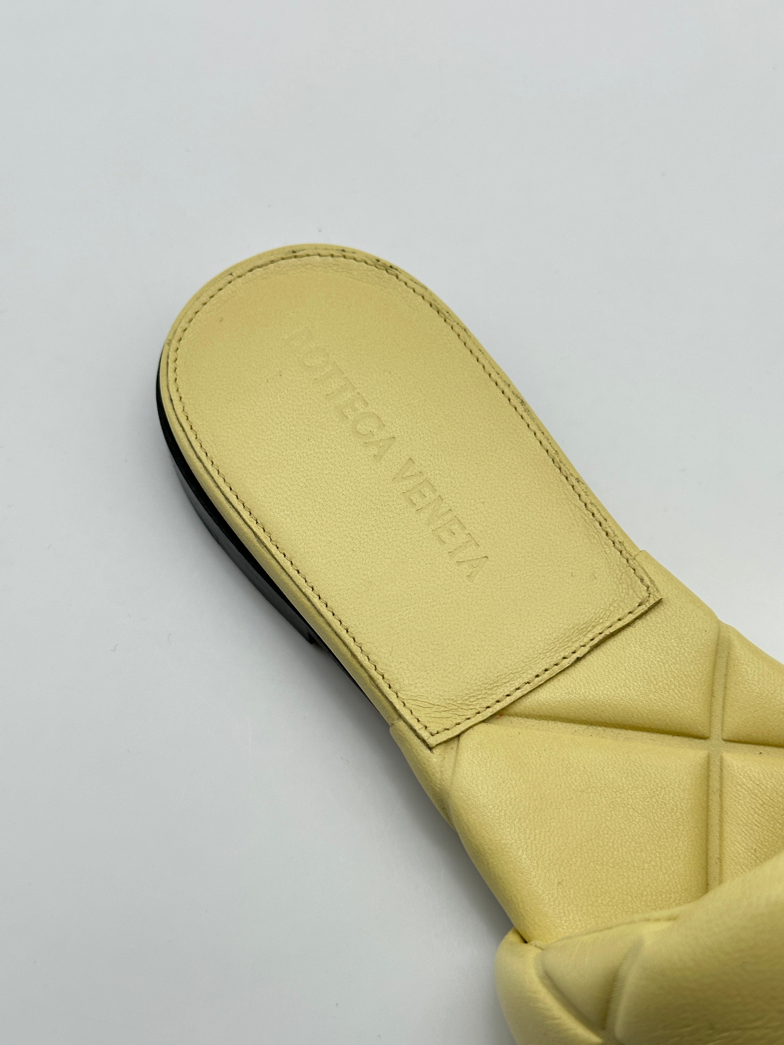 Flat Padded Sandal con punta squadrata, pelle trapuntata imbottita e tacco a blocco. Design elegante e confortevole.