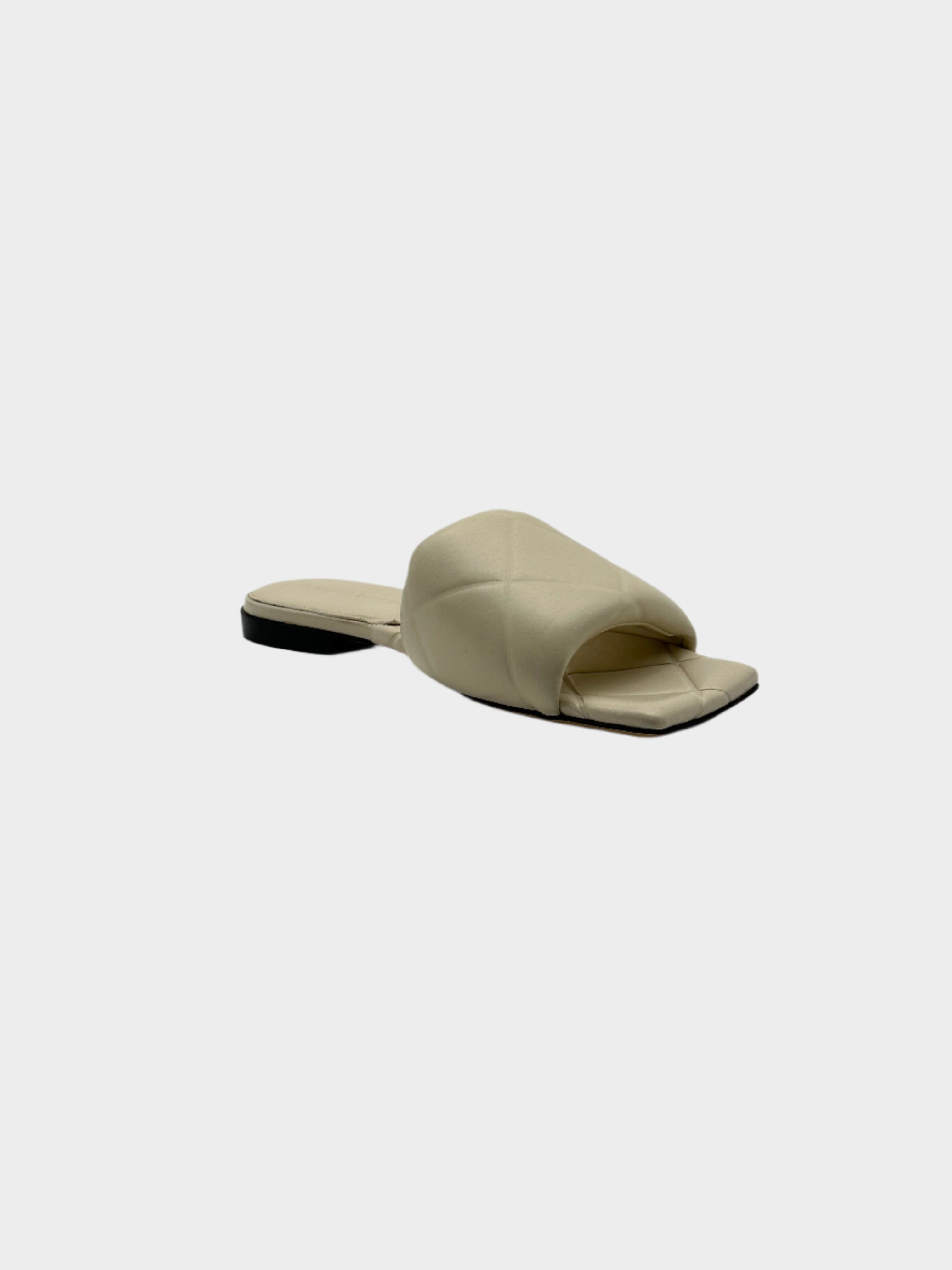 Flat Sandals con punta squadrata, logo impresso sulla suola e tacco basso. Stile minimalista e raffinato.