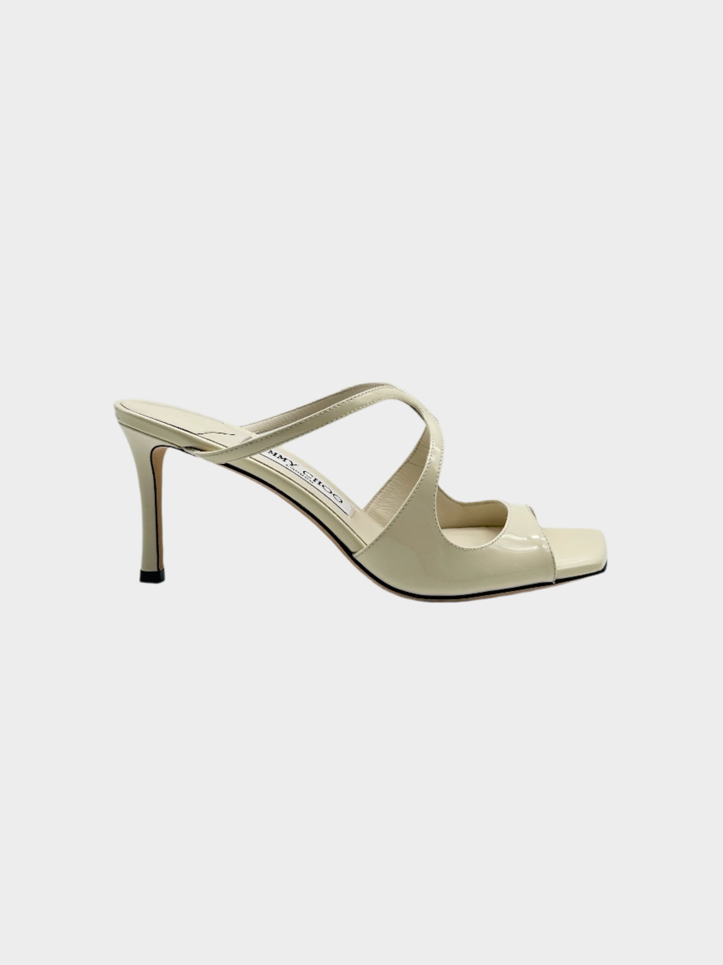 Latte Patent Leather Mules in pelle verniciata crema con punta aperta squadrata, tacco a stiletto da 7,5 cm e suola in pelle.