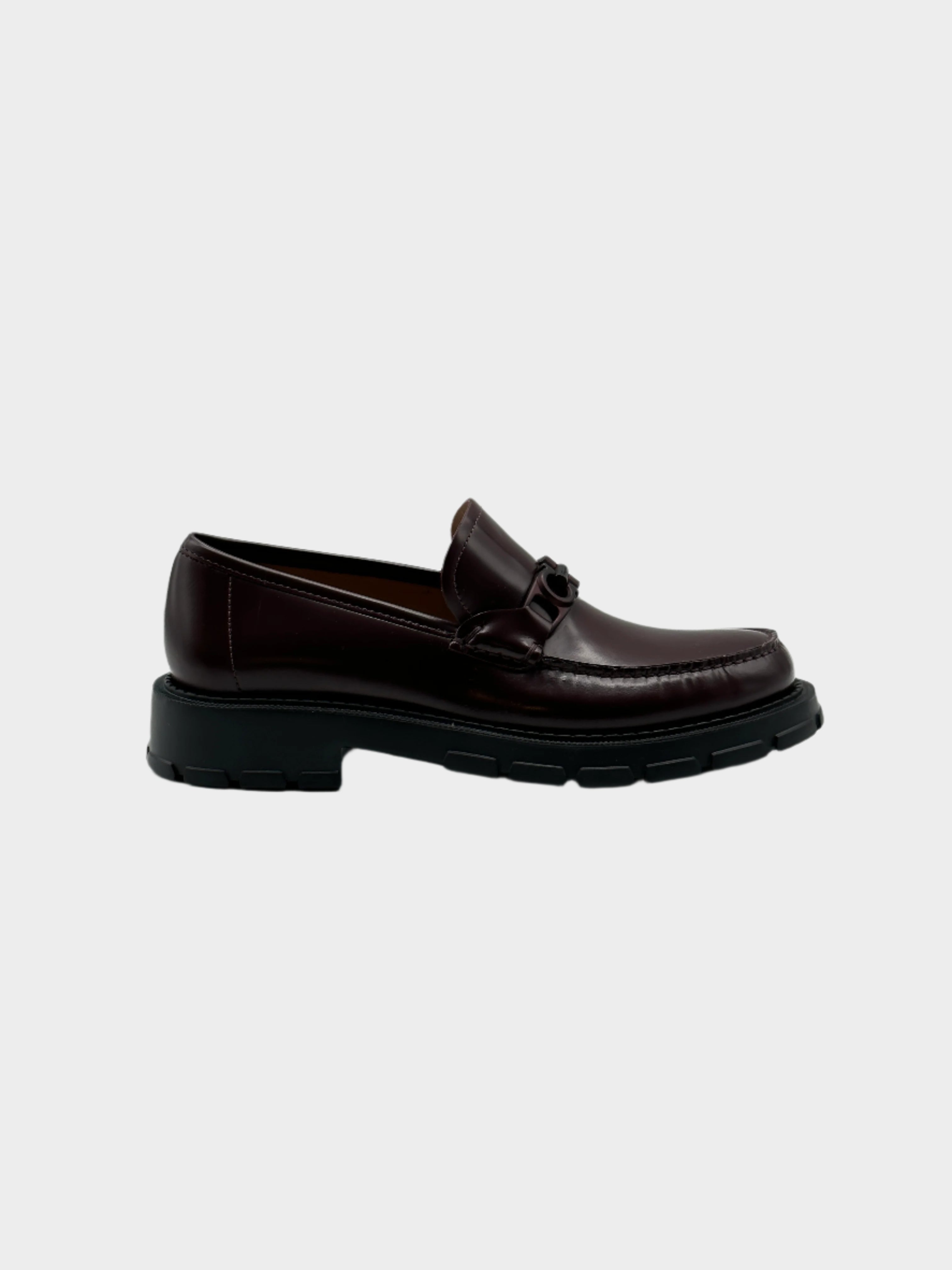 Patent Leather Loafers con punta tonda, placca logo in metallo marrone e suola chunky in gomma. Eleganza moderna e comfort.