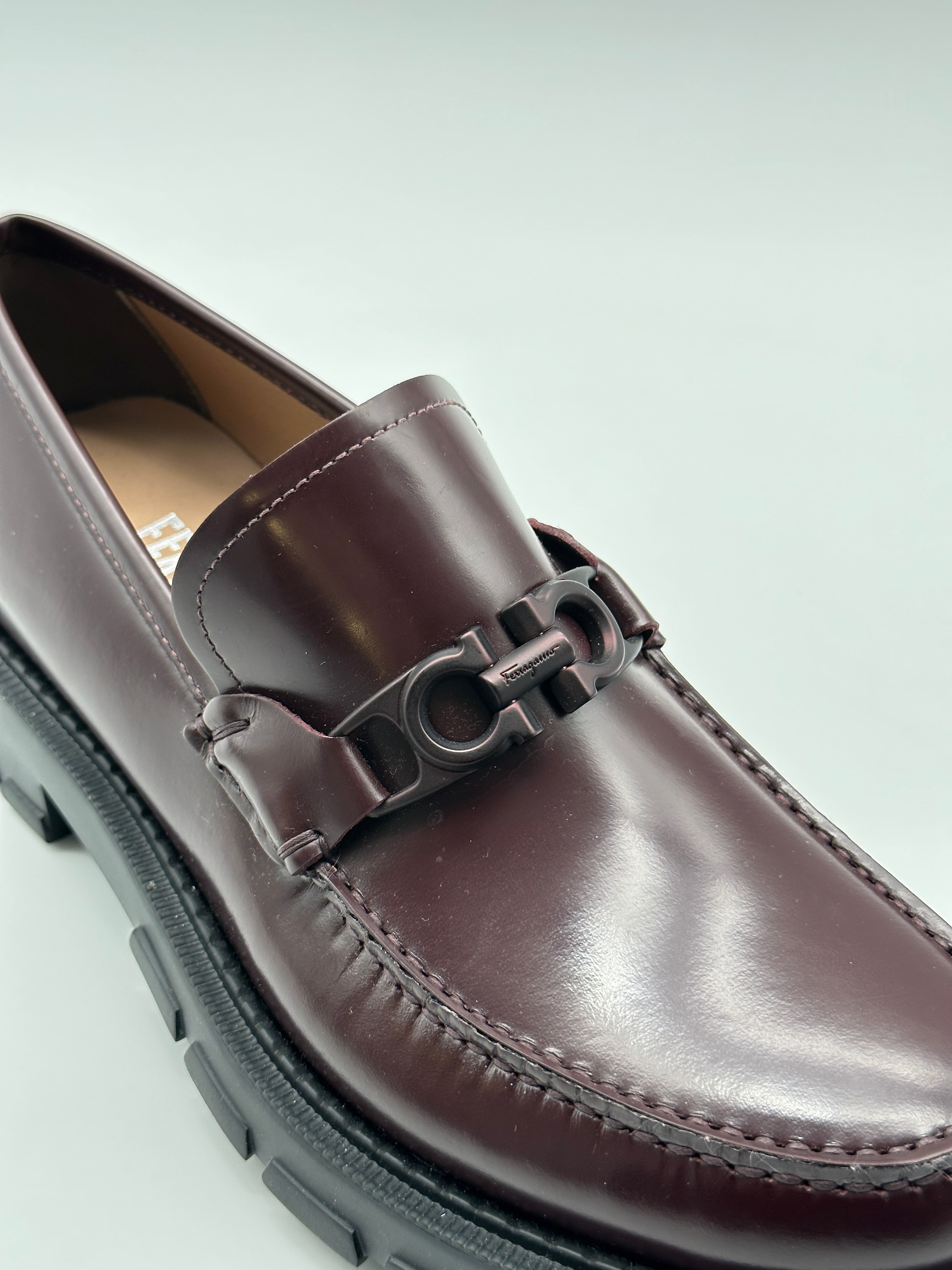 Patent Leather Loafers con punta tonda, placca logo in metallo marrone e suola chunky in gomma. Eleganza moderna e comfort.