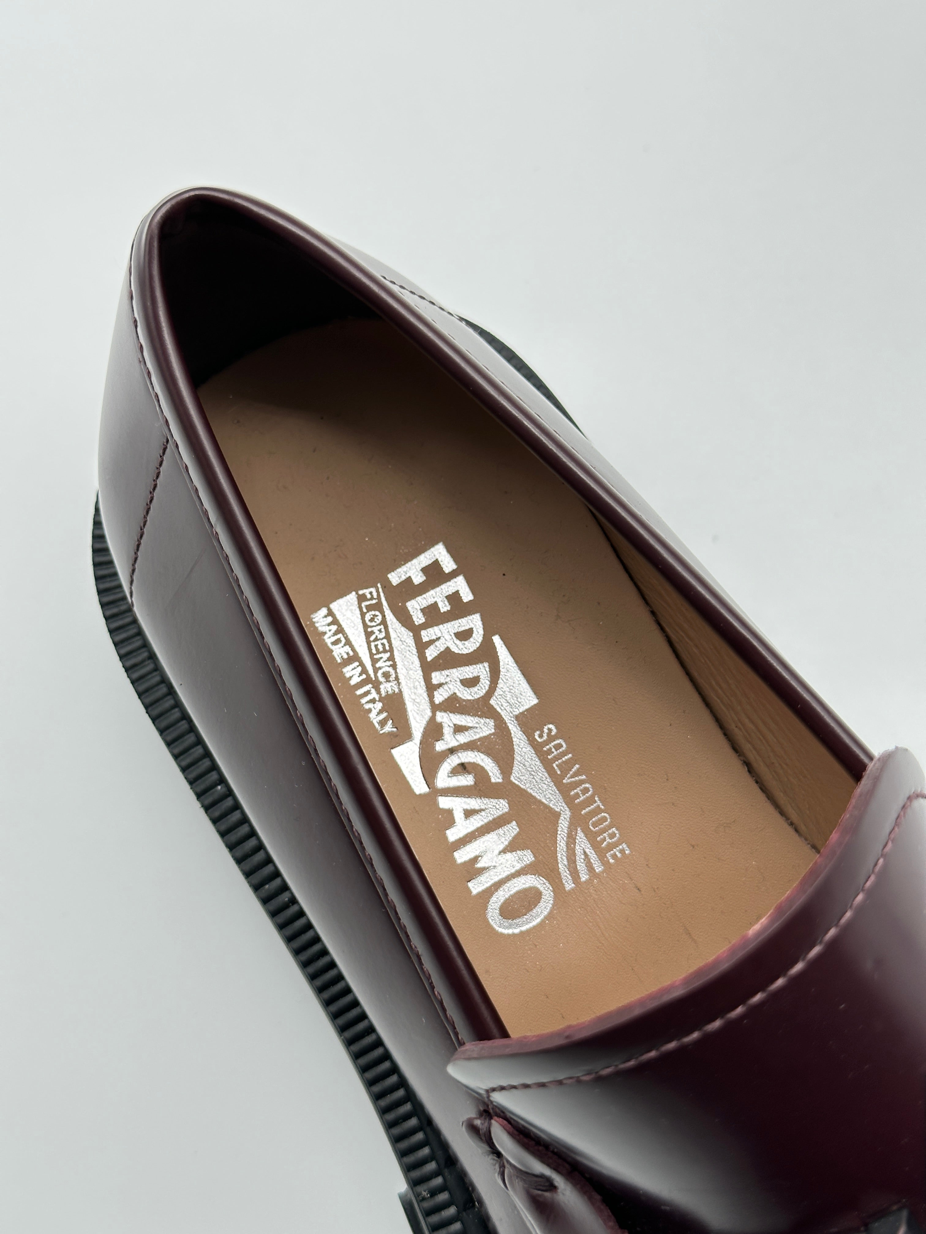 Patent Leather Loafers con punta tonda, placca logo in metallo marrone e suola chunky in gomma. Eleganza moderna e comfort.