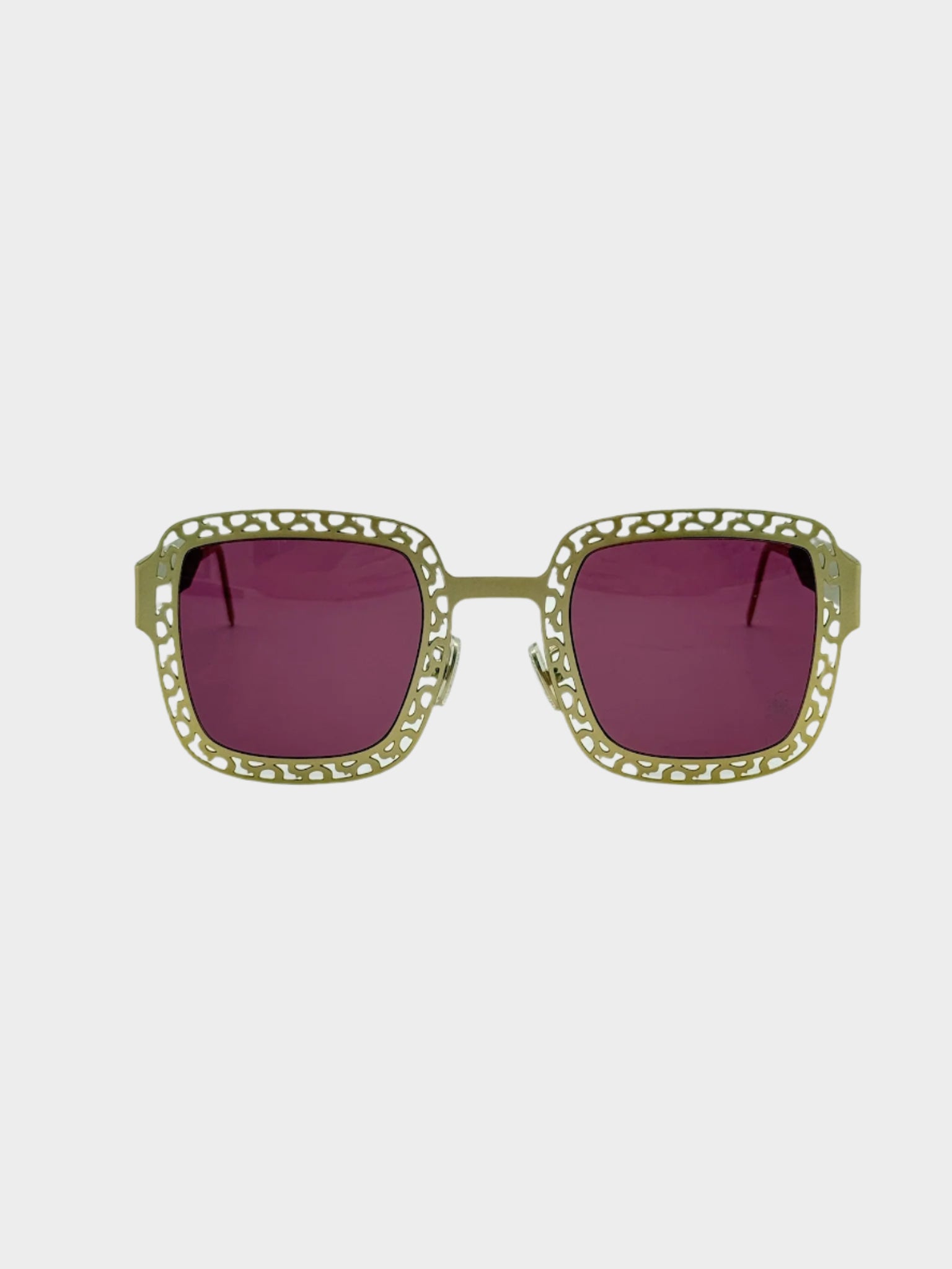Vista frontale degli occhiali Philipp Plein con montatura traforata oro e lenti rosa