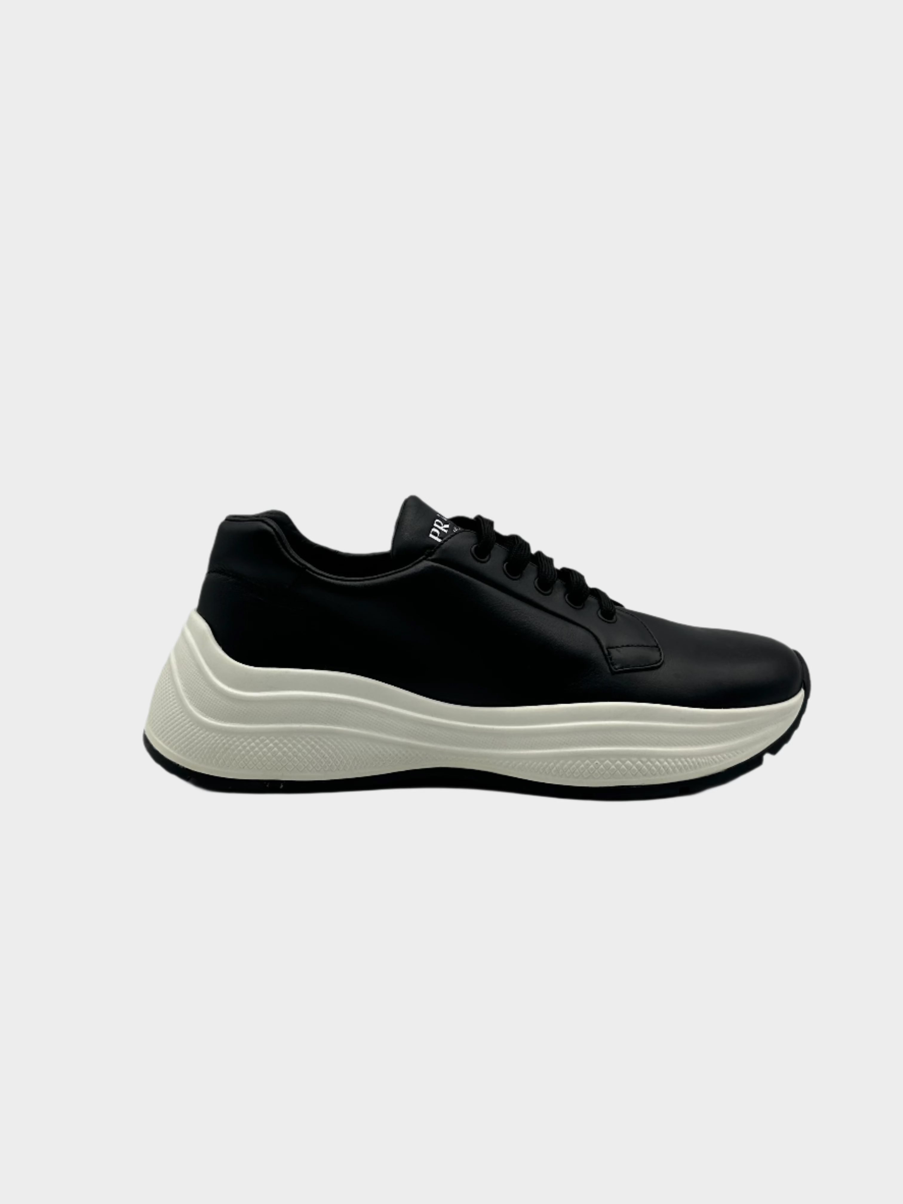 Sneakers Prada nere in pelle con suola bianca e logo sul retro

