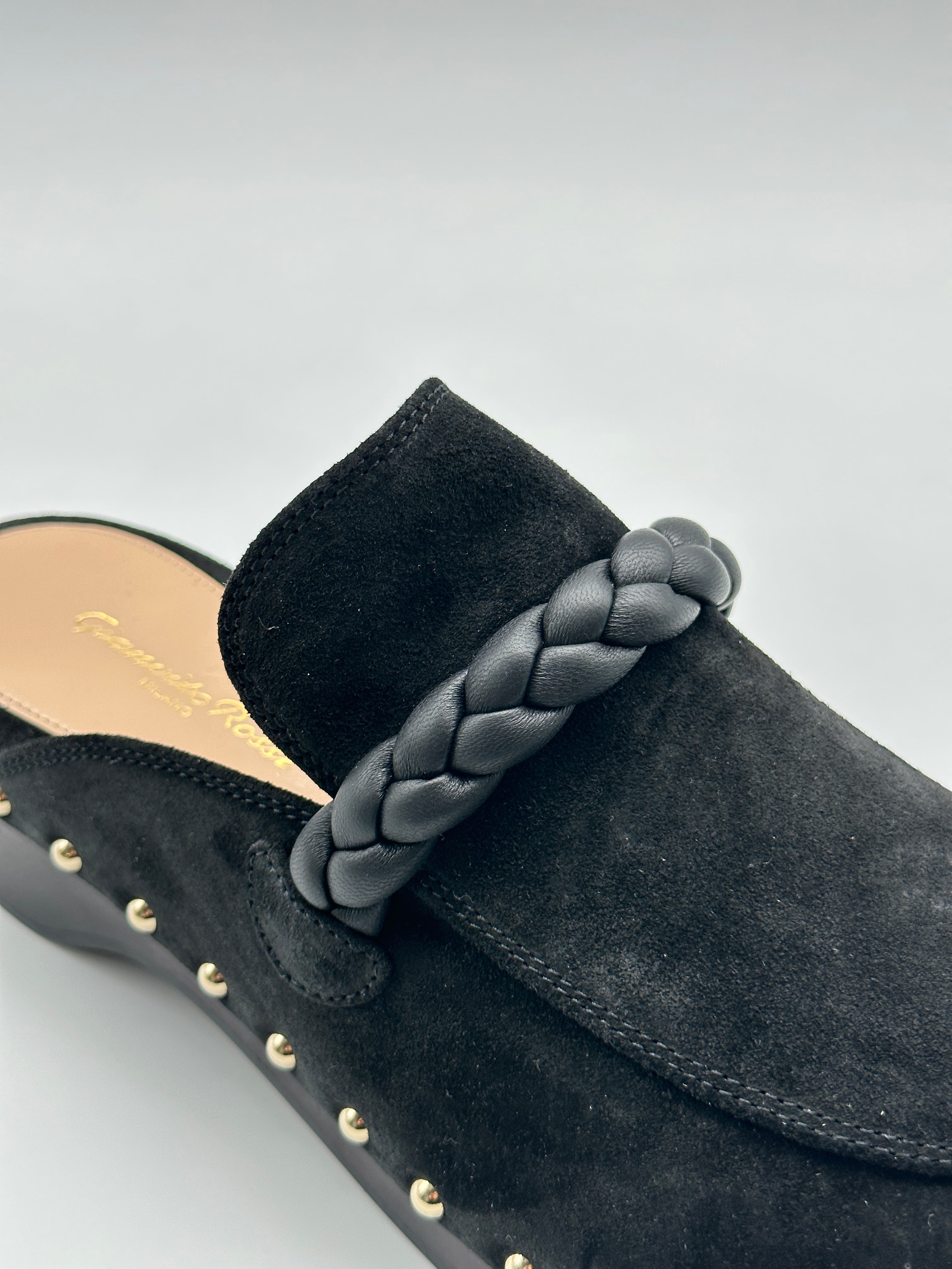 Suede Mules con punta tonda, dettaglio in pelle intrecciata, borchie laterali e tacco di 5 cm. Eleganza e comfort.