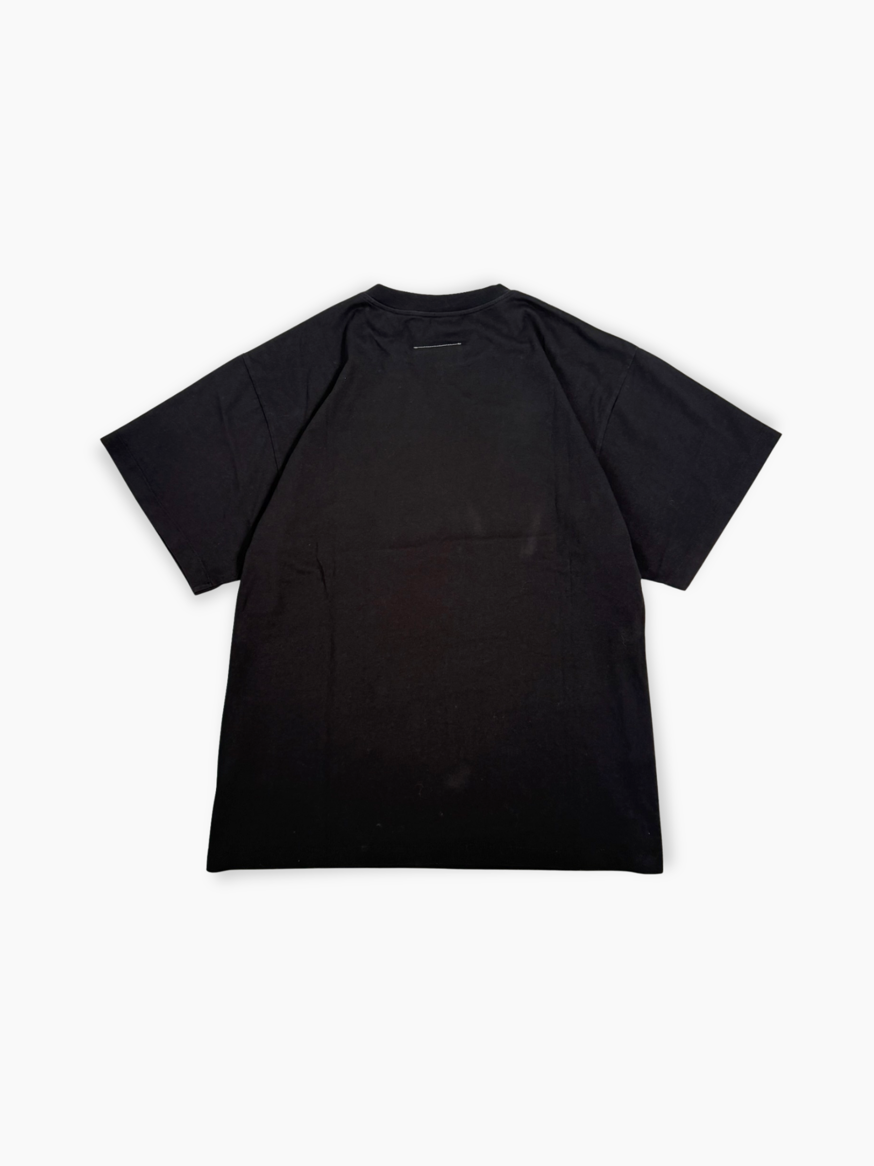 Dettaglio stampa gialla Welcome con grafica palazzo su T-shirt nera Maison Margiela