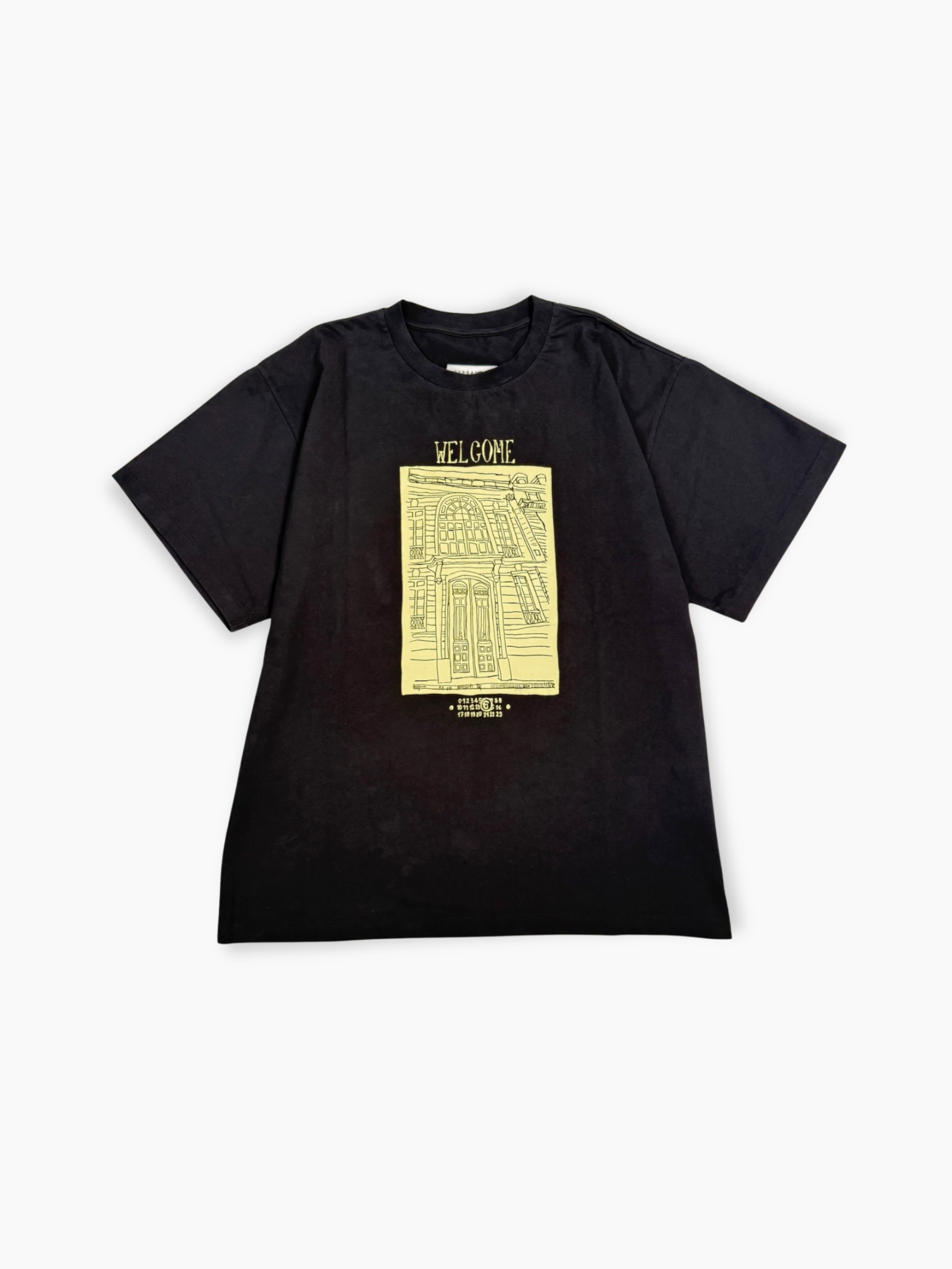 T-shirt nera Maison Margiela con stampa gialla Welcome e grafica palazzo vista frontale
