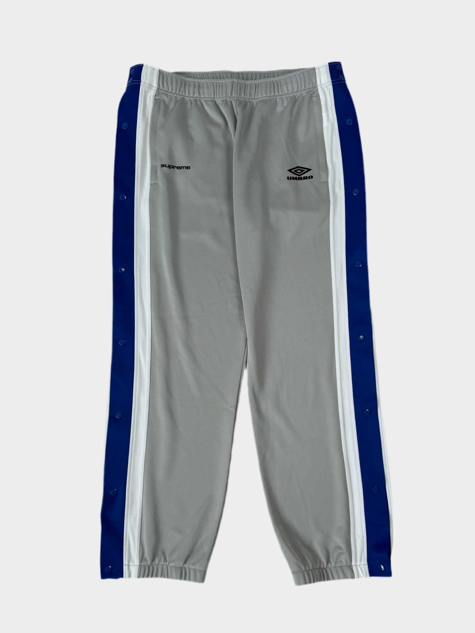 Vista frontale del pantalone della tuta Umbro x Supreme in acetato grigio