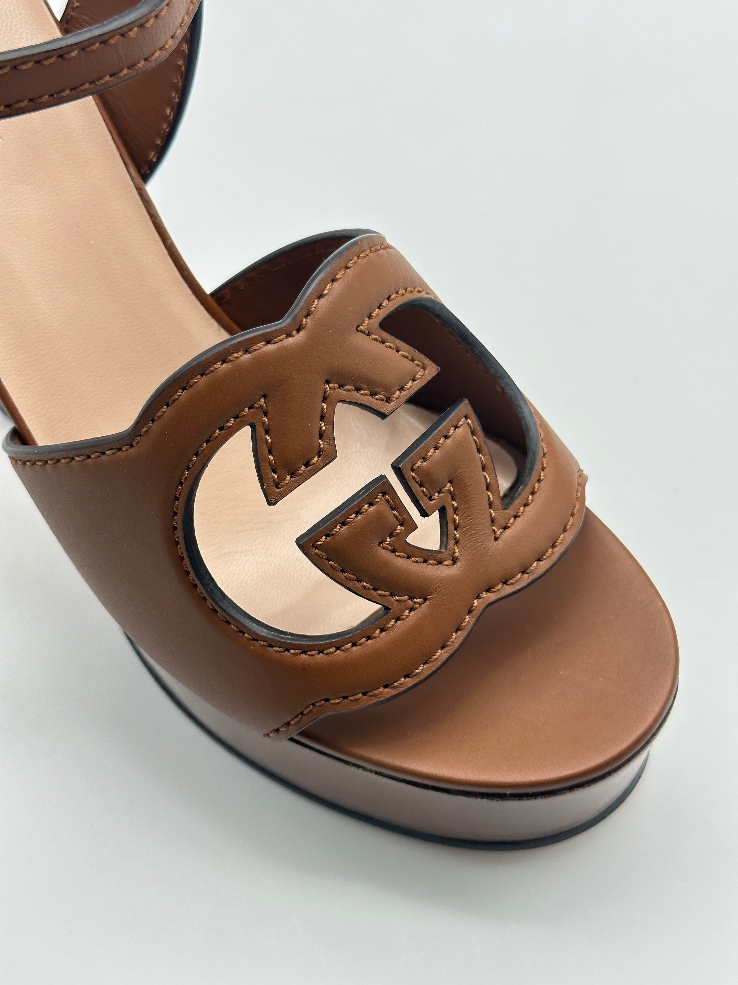 Wood Heels con punta arrotondata, cinturino regolabile, logo in pelle e suola con motivo legno. Eleganza e comfort.